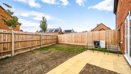 Rear garden with paved patio, airsource heat pump, lawn and fenced boundaries.