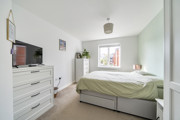 Bedroom with double bed, chest of drawers, television and window.