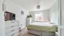 Bedroom with double bed, chest of drawers, television and window.