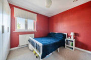 Bedroom with a double bed, bedside tables and red feature walls.