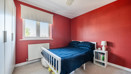 Bedroom with a double bed, bedside tables and red feature walls.