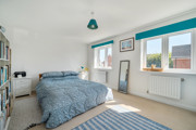 Bedroom with double bed, large window and fitted storage units.