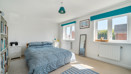 Bedroom with double bed, large window and fitted storage units.