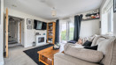 Living room with a sofa, coffee table, wall-mounted TV and balcony doors.