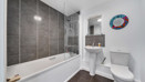 Bathroom with bathtub, wall tiles, sink and toilet.
