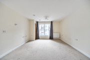 Empty bedroom with window, curtains and wall-mounted radiator.
