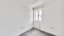 Empty bedroom with window and grey carpet.