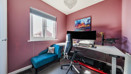 Home office with desk, computer setup, chair and window.