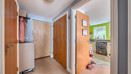 Hallway with doors and view into the kitchen.