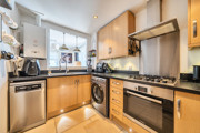 Kitchen with wooden cabinets, appliances, window and sink.