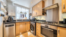 Kitchen with wooden cabinets, appliances, window and sink.