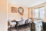 Open-plan dining area with table, chairs and large window.