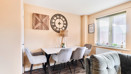 Open-plan dining area with table, chairs and large window.