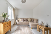 Living room with corner sofa, chest of drawers and window.
