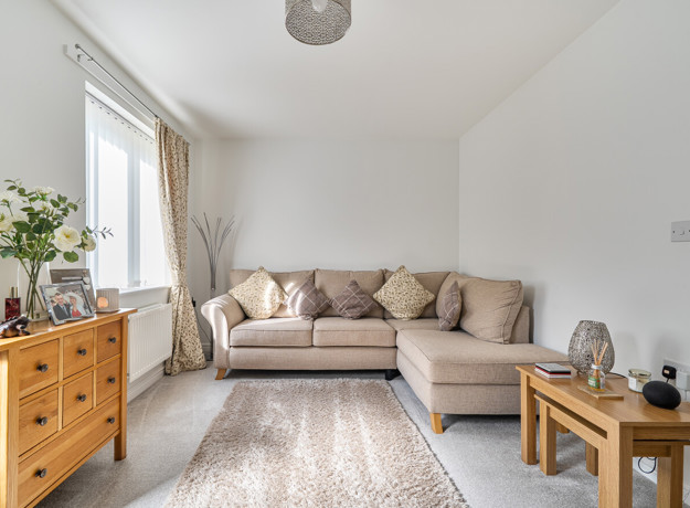 Living room with corner sofa, chest of drawers and window.