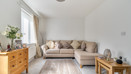 Living room with corner sofa, chest of drawers and window.
