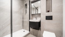 Bathroom with shower enclosure, vanity unit, mirror and wall-mounted cabinet.