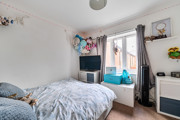 Bedroom with double bed, television, window and storage units.