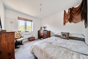 Bedroom with double bed, wooden furniture and window.