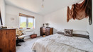 Bedroom with double bed, wooden furniture and window.