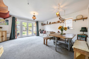 Open-plan living and dining area with table, chairs and patio doors.