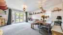 Open-plan living and dining area with table, chairs and patio doors.