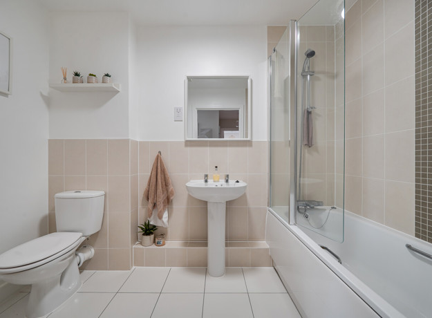 Bathroom with bath, shower screen, toilet and pedestal sink.