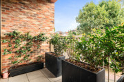 Private balcony with planter boxes, climbing plants and surrounding greenery.