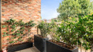 Private balcony with planter boxes, climbing plants and surrounding greenery.