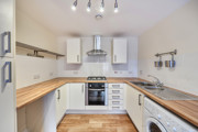 Fitted kitchen with oven, hob, extractor fan and worktops.