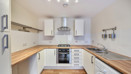 Fitted kitchen with oven, hob, extractor fan and worktops.