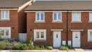 Front elevation of a red brick terraced house with neighbouring properties.
