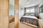 Bedroom with double bed, wardrobe, bedside tables and window.