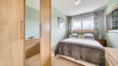 Bedroom with double bed, wardrobe, bedside tables and window.