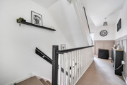 Landing with staircase, wall shelf and doors leading to rooms.