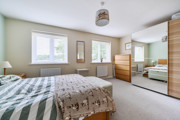 Bedroom with double bed, mirrored wardrobe, and window allowing natural light.