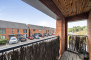 Balcony overlooking a residential street with parked cars.