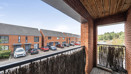 Balcony overlooking a residential street with parked cars.