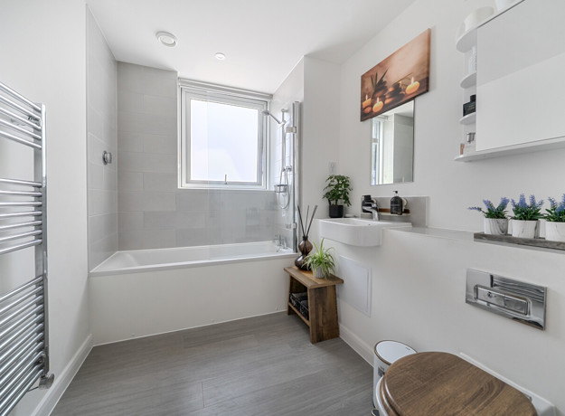 Bathroom with bath, shower attachment, wash basin and toilet.