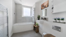 Bathroom with bath, shower attachment, wash basin and toilet.