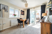 Dining area with a table and chairs beside glass doors to a balcony.