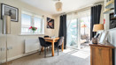 Dining area with a table and chairs beside glass doors to a balcony.