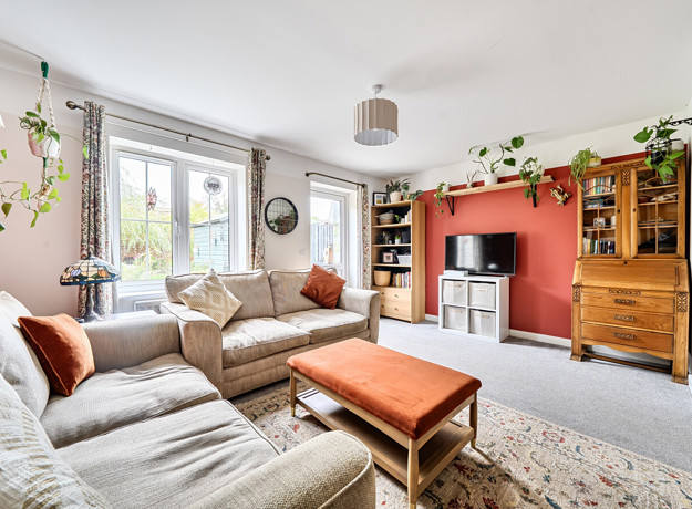 Living room with sofas, coffee table, shelving and TV.