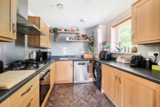 Kitchen with wooden cabinets, countertops and fitted appliances.