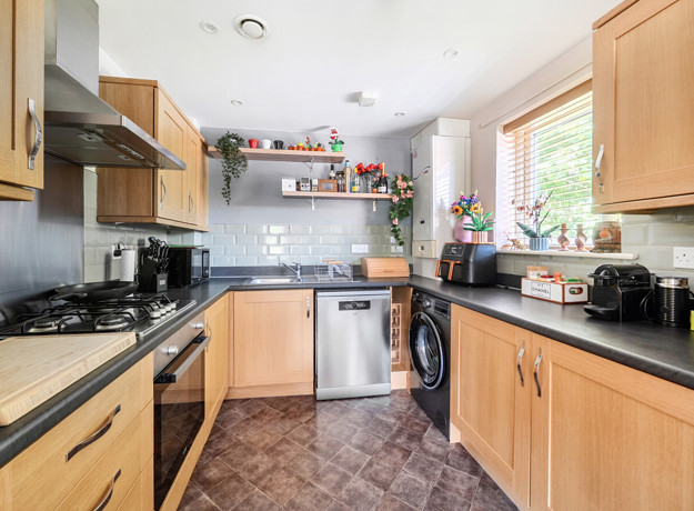 Kitchen with wooden cabinets, countertops and fitted appliances.