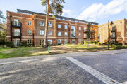 Apartment building with landscaped grounds and paved pathway.