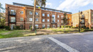 Apartment building with landscaped grounds and paved pathway.