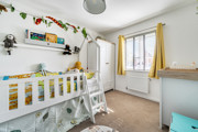 Bedroom with children's bunk bed, wardrobe and window with curtains.