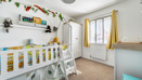 Bedroom with children's bunk bed, wardrobe and window with curtains.
