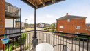 Covered balcony with metal railings and views of neighbouring apartments.